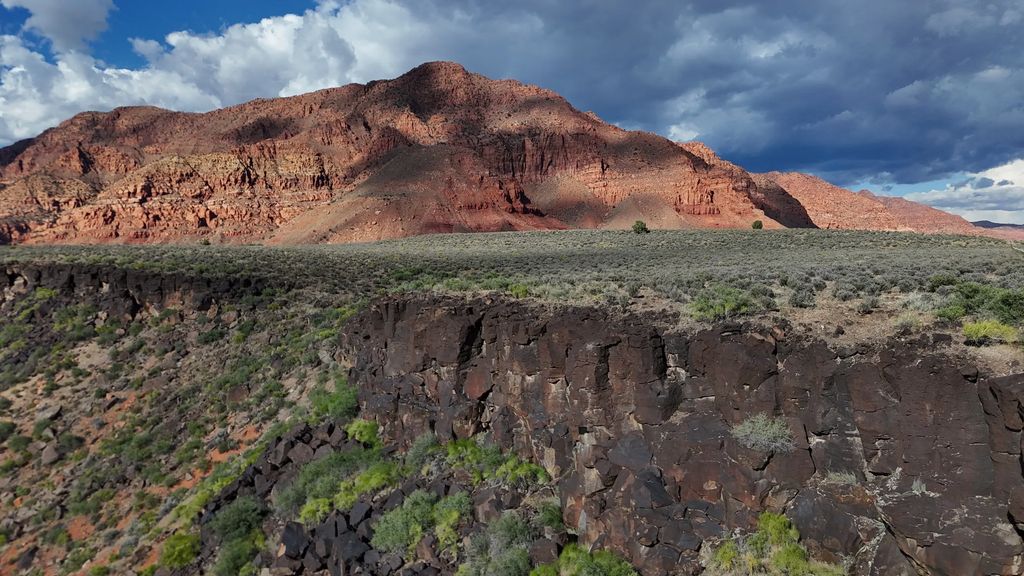 Black lava rock and desert shrubs below Red Mountain near Ivins, Utah